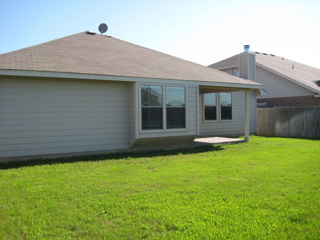 Rear view of house featuring a patio area and a shingled roof | Image 14