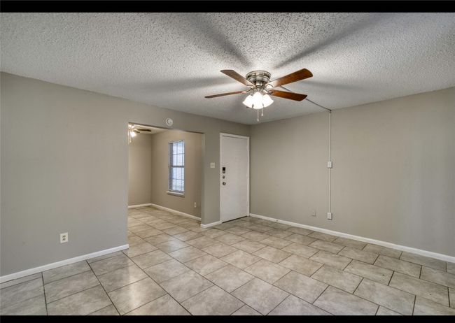 Unfurnished room with ceiling fan, a textured ceiling, and light tile patterned floors | Image 14