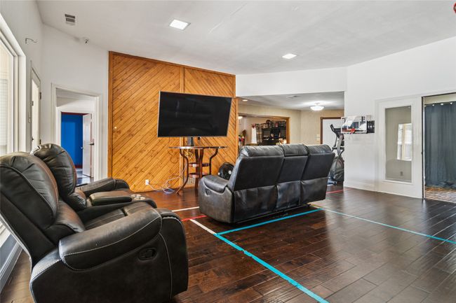 Living area with wood walls, hardwood / wood-style flooring, and an accent wall | Image 10