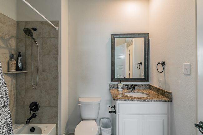 Bathroom with toilet, vanity, and shower / bath combination with curtain | Image 11