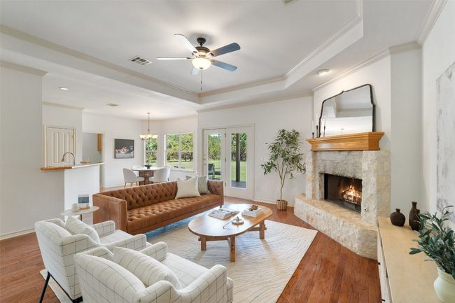 The spacious living room features a lovely stacked stone corner fireplace, perfect for cozy evenings. | Image 4