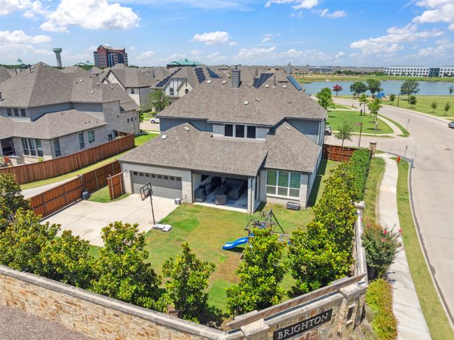 View of front of house featuring roof with shingles, a water view, an attached garage, and concrete driveway | Image 38