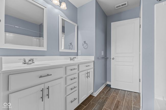 Full bath with double vanity and wood finish floors | Image 24