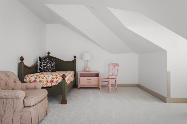 One of the upstairs bedrooms in the main home featuring two charming dormers and plenty of room for furnishings or play area | Image 22