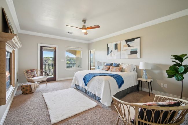 Carpeted bedroom featuring a ceiling fan, baseboards, visible vents, crown molding, and access to outside | Image 20