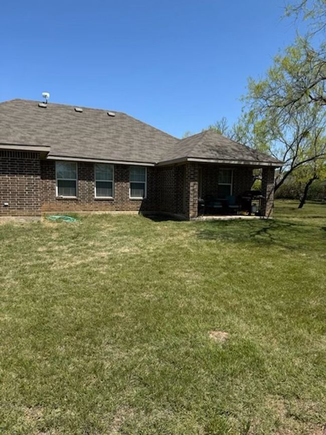Rear view of property featuring brick siding and a lawn | Image 19