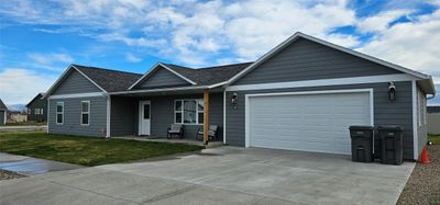 Ranch-style house featuring a front yard and a garage | Image 1