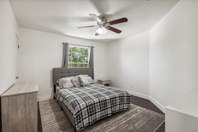 Bedroom with wood finished floors, baseboards, and ceiling fan | Image 23