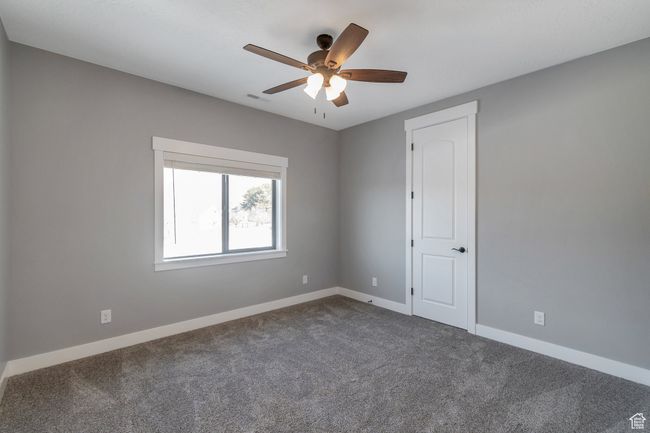 Spare room featuring dark colored carpet and ceiling fan | Image 26