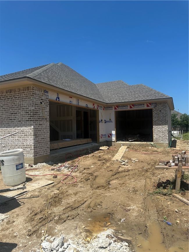 View of side of home featuring brick siding, roof with shingles, and an attached garage | Image 5