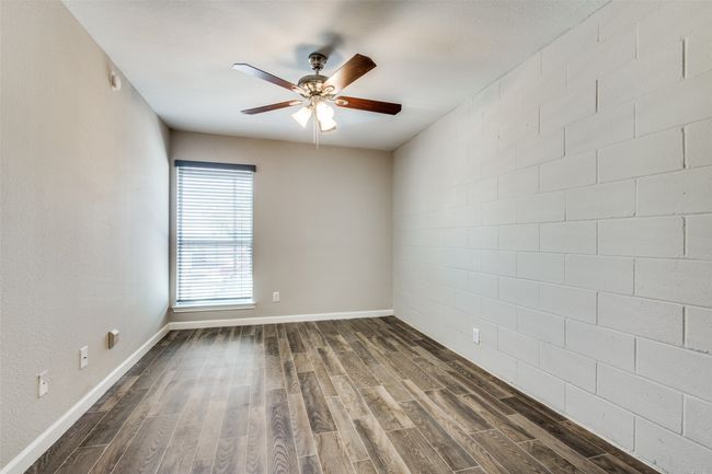 Unfurnished room featuring dark wood-style floors, baseboards, and a ceiling fan | Image 9