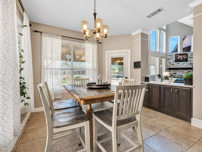 Dining area featuring visible vents, a notable chandelier, baseboards, and light tile patterned floors | Image 14