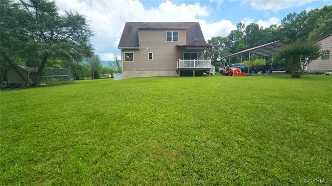 Back of house with a carport, a lawn, and roof with shingles | Image 36