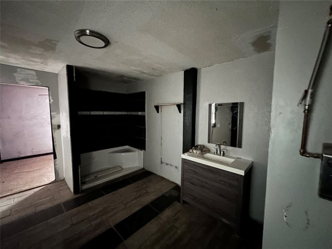 Bathroom featuring vanity, a textured ceiling, and wood tiled floors | Image 10