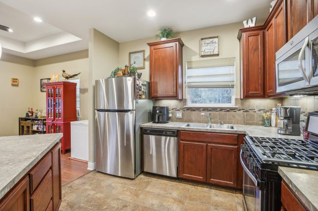 Kitchen featuring tasteful backsplash, appliances with stainless steel finishes, and sink | Image 17