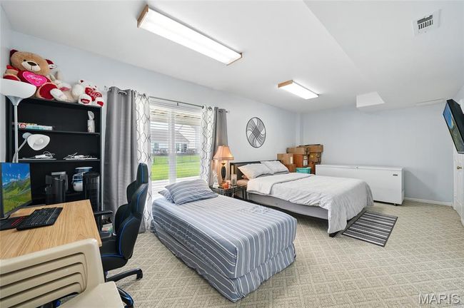 Bedroom with carpet floors and an office area | Image 18