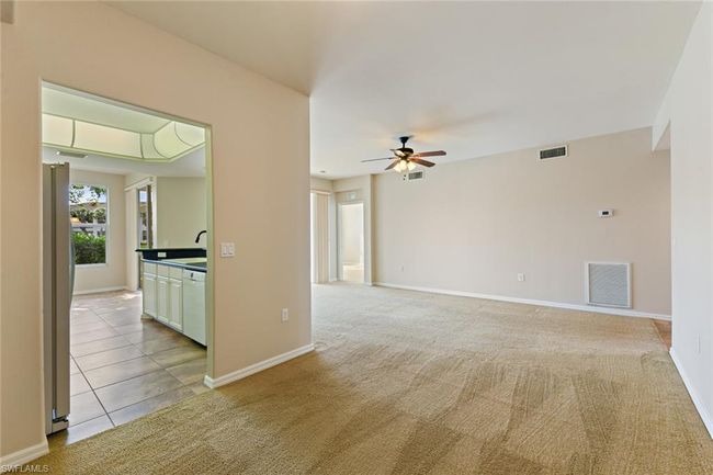 Unfurnished room with ceiling fan, light colored carpet, and visible vents | Image 15
