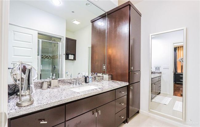 Bathroom with tile patterned flooring, vanity, and a shower with door | Image 22