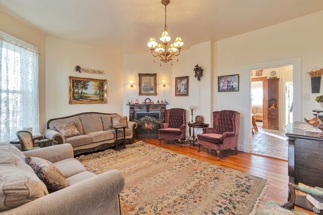 Living room featuring light wood-type flooring, a chandelier, and a healthy amount of sunlight | Image 20