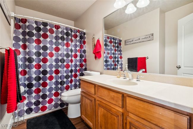 Full bathroom featuring toilet, vanity, wood finished floors, and curtained shower | Image 26