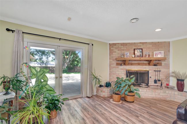Living room with a fireplace, french doors, wood finished floors, and ornamental molding | Image 10