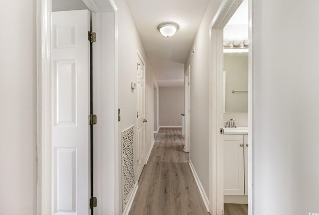 Corridor with baseboards and light wood-style flooring | Image 11