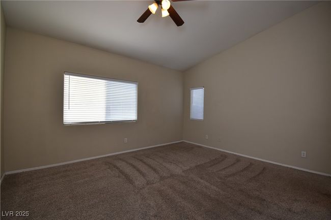 Spare room featuring vaulted ceiling, baseboards, carpet, and ceiling fan | Image 20