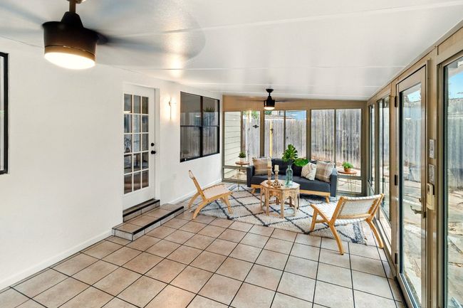 Sun-filled, air-conditioned sunroom provides flexible space for a second living area, home office, gym, or entertainment zone. With tile flooring and expansive backyard views, it’s a perfect bridge between indoor comfort and outdoor charm. | Image 19