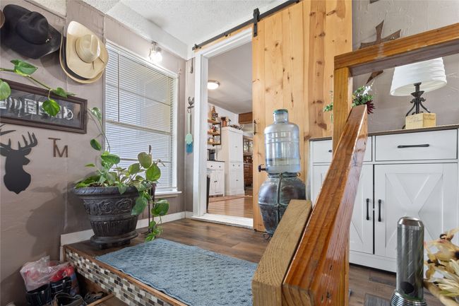 Foyer entrance with wood finished floors, a barn door, and a textured ceiling | Image 20