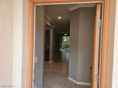 Corridor with ornamental molding and light tile floors | Image 3