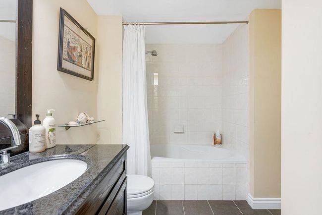 Full bath featuring tile patterned flooring, vanity, toilet, and tiled shower / bath | Image 20