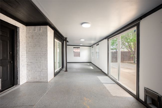 Corridor featuring speckled floor and brick wall | Image 14