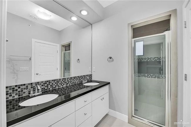 Bathroom with a shower stall, double vanity, tasteful backsplash, and recessed lighting | Image 16