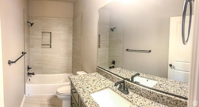 Bathroom with toilet, baseboards, tile patterned flooring, vanity, and shower / tub combination | Image 17