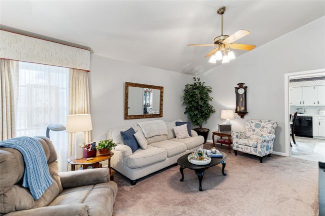 Enjoy a comfortably sized living area (18x12) filled with natural sunlight, offering an open view into the kitchen and dining spaces for easy everyday living & entertaining. | Image 6