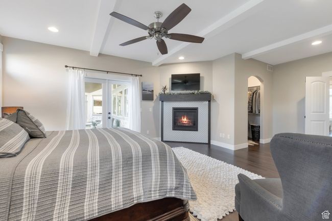Bedroom with baseboards, arched walkways, beamed ceiling, wood finished floors, and french doors | Image 21
