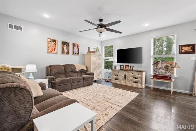 Living area with a ceiling fan, recessed lighting, and dark wood-style floors | Image 5
