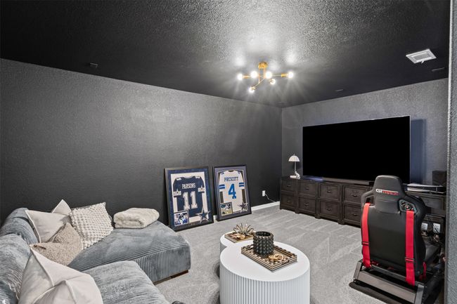 Living room featuring a textured wall, carpet floors, a chandelier, and a textured ceiling | Image 26