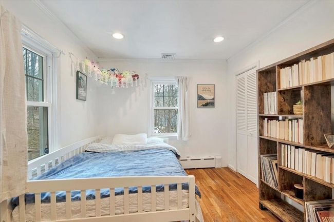 Bedroom with visible vents, ornamental molding, light wood-style floors, and baseboard heating | Image 15