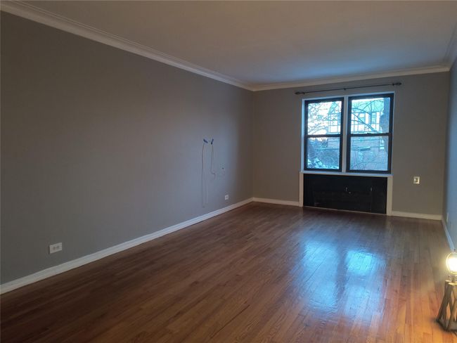 Empty room with baseboards, dark wood-style flooring, and crown molding | Image 14