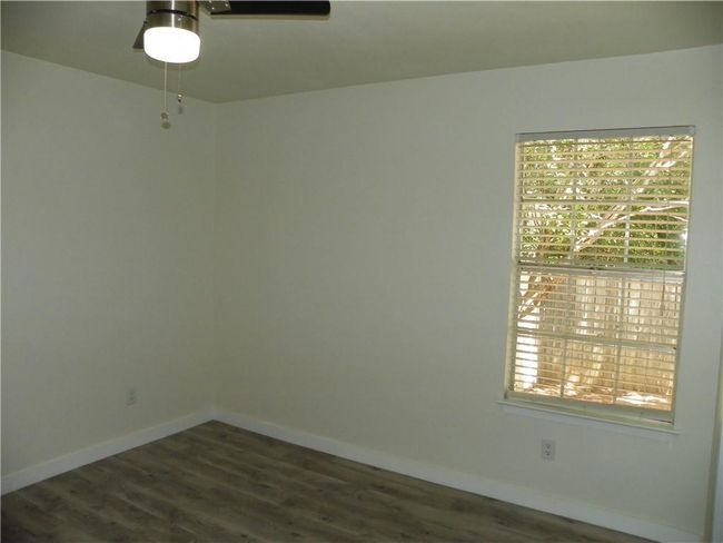 Spare room with a ceiling fan and dark wood finished floors | Image 14