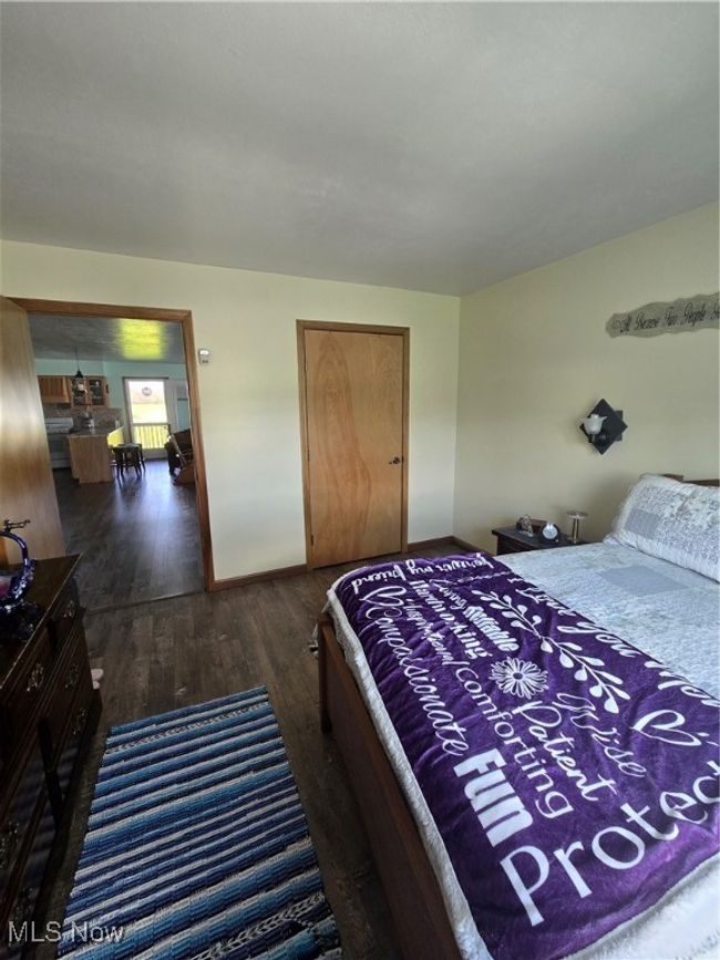 Bedroom with a closet, baseboards, and dark wood-style flooring | Image 38