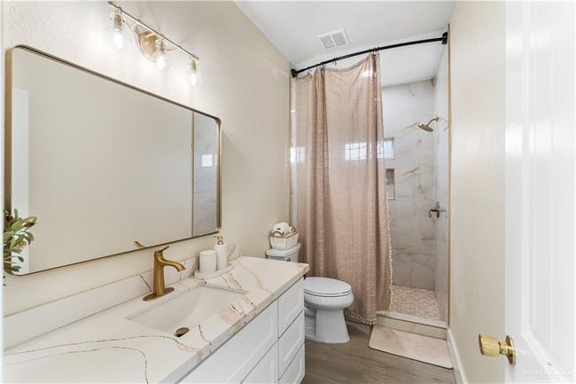 Bathroom featuring vanity, a shower with curtain, hardwood / wood-style floors, and toilet | Image 16