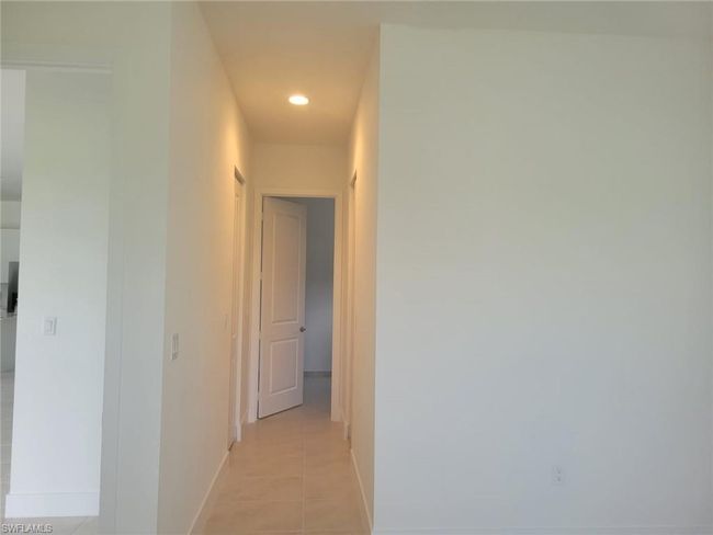 Corridor with light tile patterned floors, recessed lighting, and baseboards | Image 9