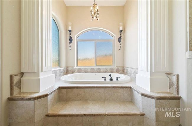 Full bath featuring plenty of natural light, a garden tub, and a chandelier | Image 22