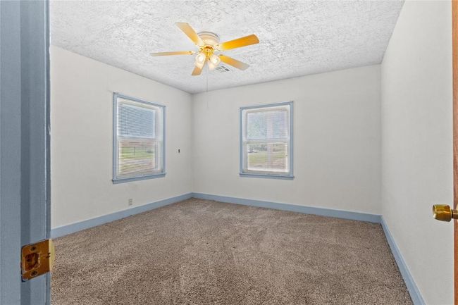 Empty room featuring a textured ceiling, carpet floors, and ceiling fan | Image 14