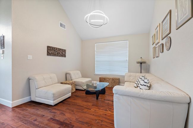 Sitting room with dark wood-type flooring and lofted ceiling | Image 7