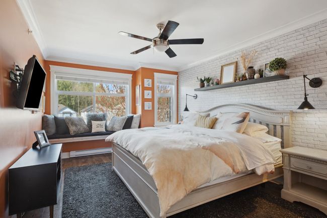 Bedroom featuring crown molding, a baseboard radiator, and brick wall | Image 15