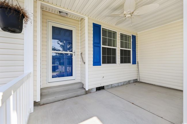 Doorway to property featuring ceiling fan and a porch | Image 4