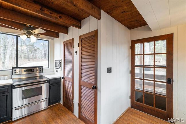 Kitchen with stainless steel appliances, beamed ceiling, wood finished floors, and wooden ceiling | Image 15